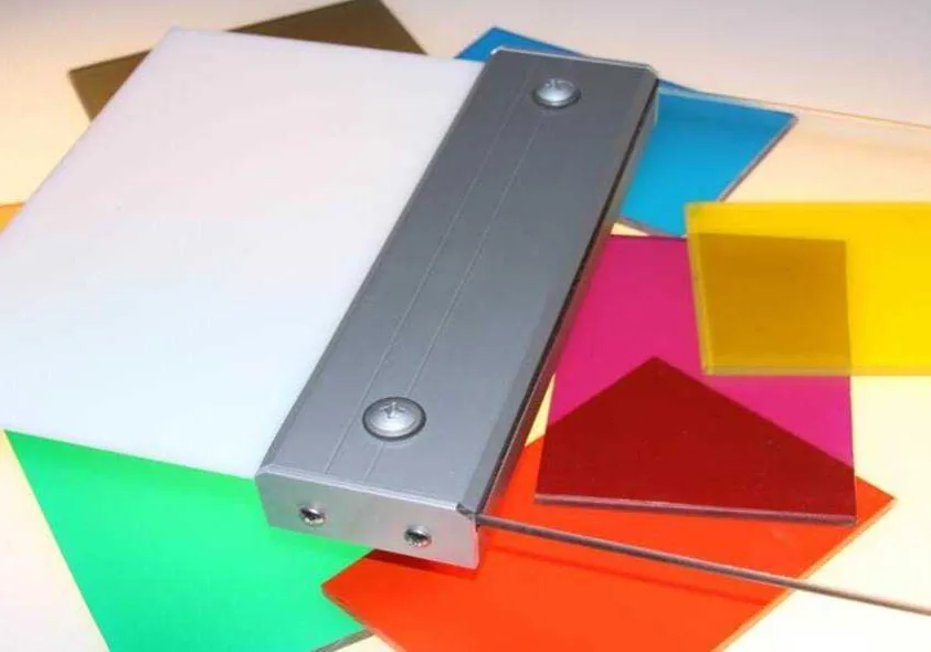 Coloured monolithic polycarbonate glazing samples held in an aluminium panel clamp